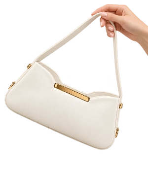 Ivory shoulder bag with gold-tone hardware held by hand