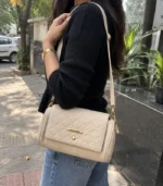 Beige quilted bag with gold-tone chain detail and adjustable strap